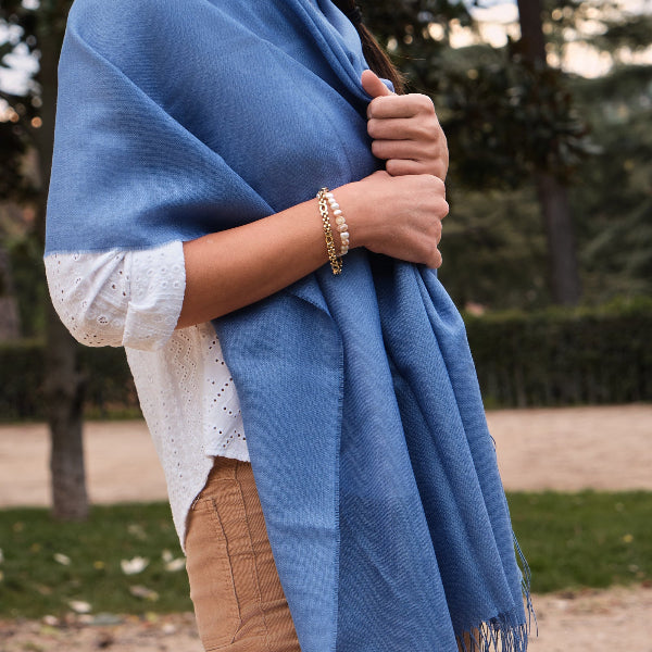 Mujer con un chal liso de baby alpaca y seda de color azul claro